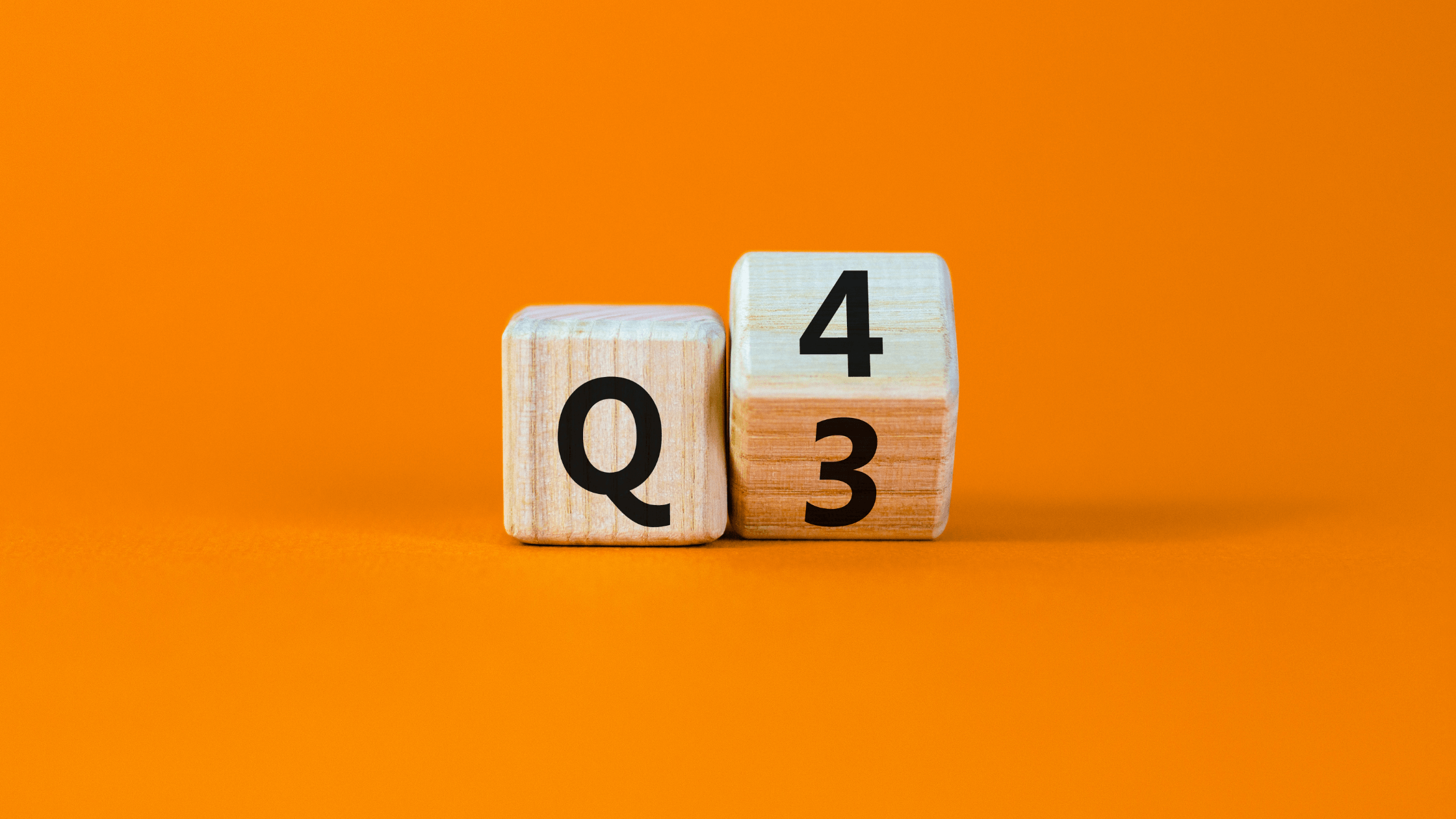 Two wooden blocks with "Q" and "4" visible, next to another block showing "3," symbolizing the strategic planning focus on the fourth quarter (Q4) for capital investments and tax planning.